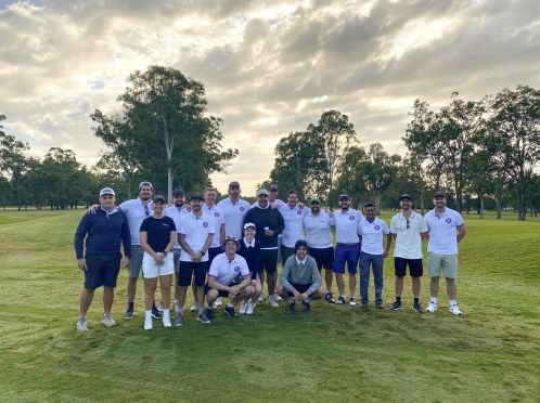 A group shot of people wearing Entain branded T-shirts on a golf course